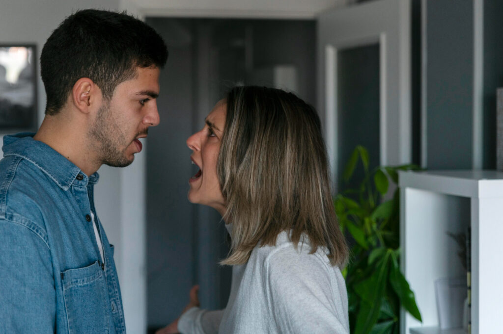 Mulher em silêncio com olhar de angústia, expressando medo de rejeição durante um momento tenso no relacionamento.