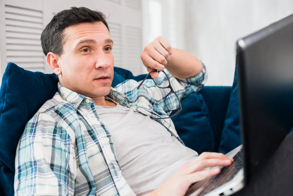 homem verificando seus ganhos de renda passiva no celular enquanto relaxa