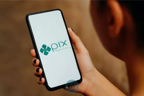 Cliente utilizando aplicativo bancário para transferência via Pix, simbolizando o impacto do Pix na economia brasileira e sua praticidade.