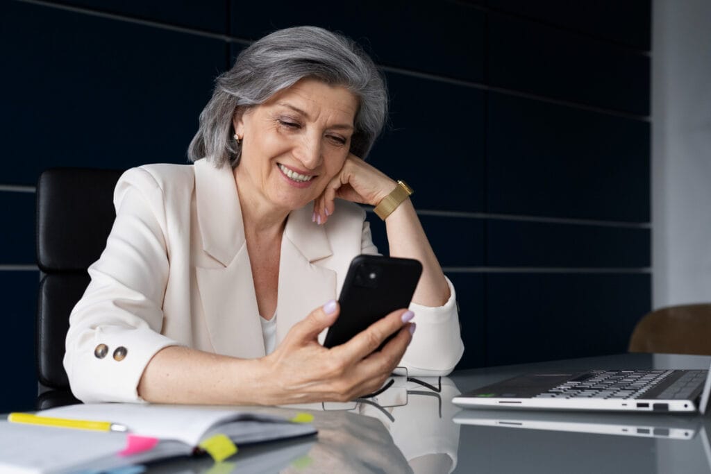 Pessoa mais velha usando o celular para transferir seu benefício do INSS para outro banco