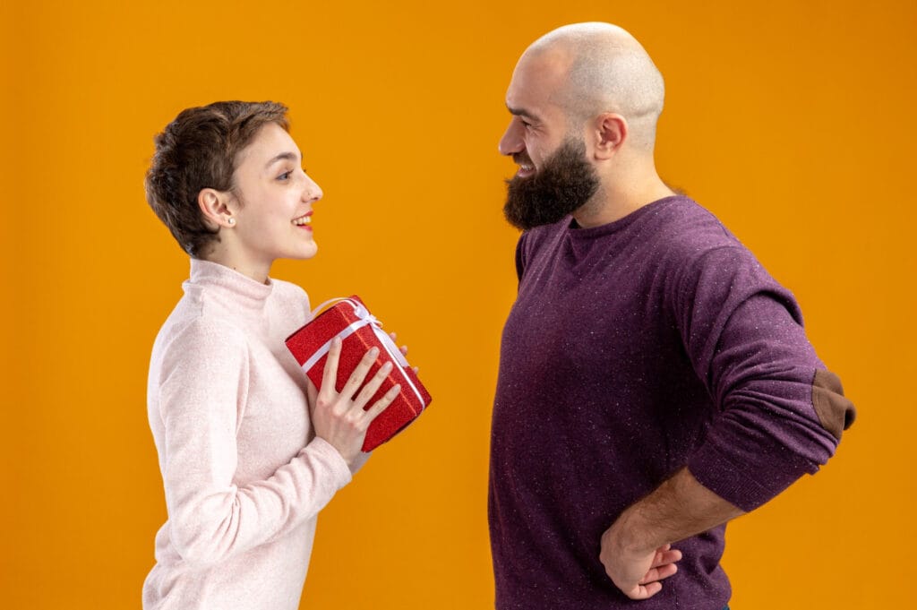 Mãos trocando um presente embrulhado, ilustrando o dilema entre generosidade e a criação de uma dívida emocional