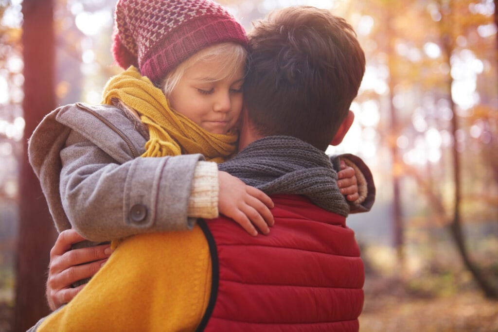 Pai consolando filho frustrado, mostrando que ensinar a lidar com a frustração é um ato de cuidado e amor.