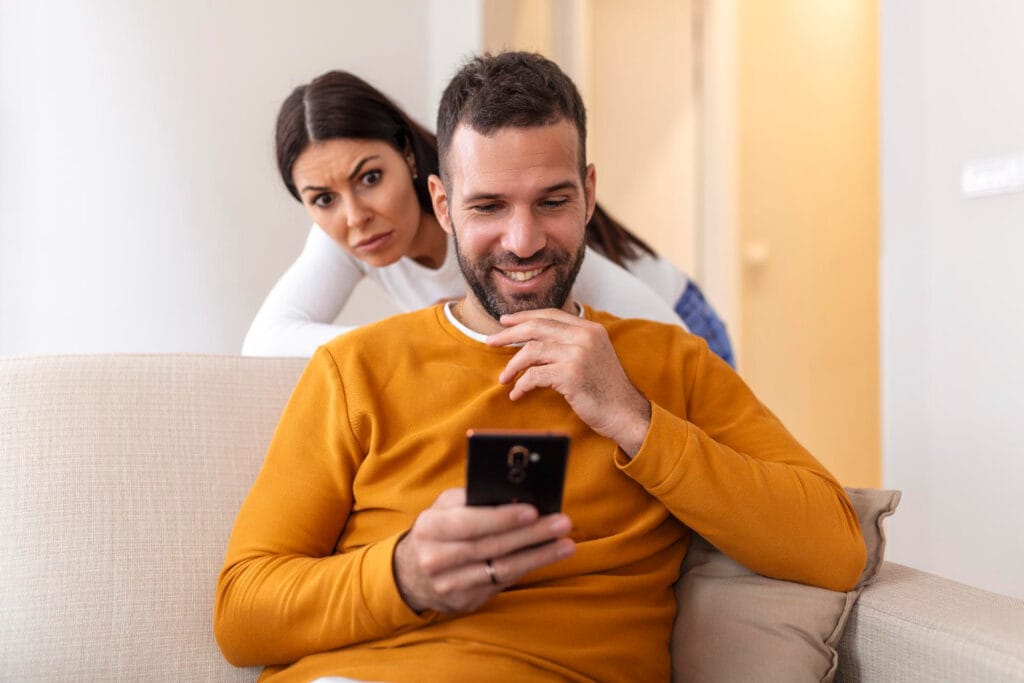 Pessoa olhando para o celular com expressão pensativa, simbolizando as dúvidas geradas por traições silenciosas